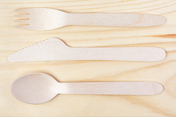 Eco-friendly materials. Wooden, disposable tableware on a wooden background.