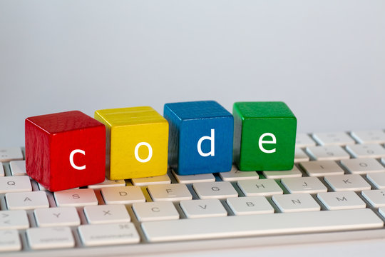 The letters code was written on blocks. These letters are written in white on red, yellow, blue and green blocks and stand on a bright computer keyboard