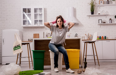 Young girl sorting garbage at the kitchen. Concept of recycling. Zero waste