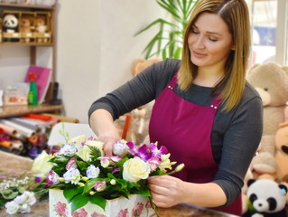 Girl with flowers. Florist at work. Flower shop. International women's day. February 14 holiday. Woman making bouquet