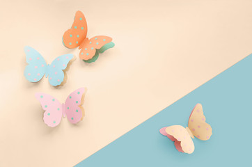 Fototapeta na wymiar Decorative cute colorful paper butterflies. Top view, copy space for your text on a blue and beige background. Beautiful desigh for Birthday, March 8, Valentine's Day