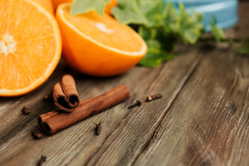  Cinnamon sticks and halves of oranges on an old wooden table copy space. Spices for mulled wine.