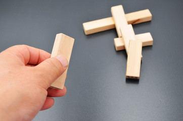 Holding a small block of wood, building blocks on a black background