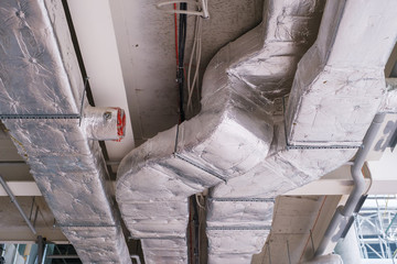 Air conditioning under a bare ceiling. ventilation pipe system at a new construction site. Bottom...