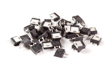 Various electronic components, D2Pack case transistors close-up on white background.