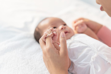Newborn baby talking to mom hold the finger of mom