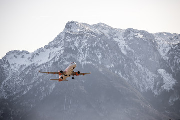 Fototapeta na wymiar Airplane scenery: take off from airport, mountain range in the alps. Travel by air, transportation
