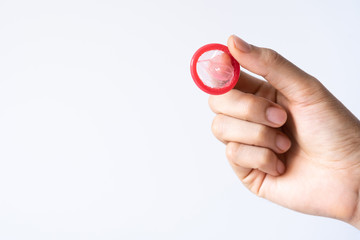A man hand holding pink condom for prevent aids in valentine' s day