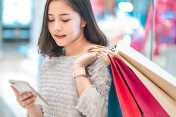 Asain woman in shopping. Happy woman with shopping bags enjoying in shopping.lifestyle concept.Smiling girl  holding colour paper bag.