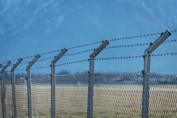 Military fence with barbed wire. Restricted area.