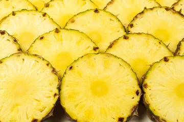 Pineapple juicy yellow slices background. Top view.