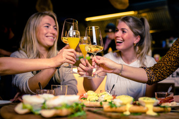 Young women in a bar having fun drinking wine