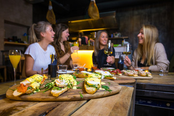 Girls having fun during a brunch with wine and food