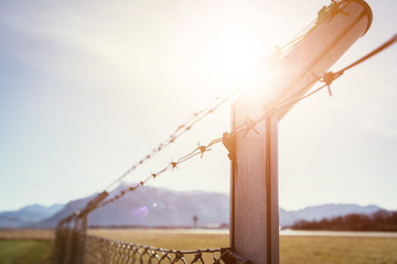 Military fence with barbed wire. Restricted area.