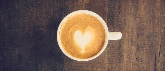 Fototapeta na wymiar panorama shot of Latte art coffee on wood table
