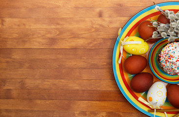 Easter cake with painted eggs on a table made of natural wood.