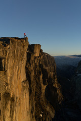 Man is putting himself to a danger. Standing at the edge of rock massive in Norway because of instagram picture.  Place is called Ekkertind which leaves in Dovrefjell national park.