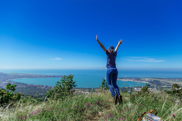 Girl jumps on the slope of a ridge.  Late spring (early summer) Gelendzhik.