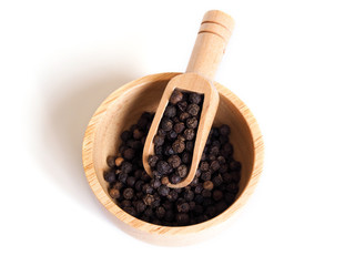Black pepper in wooden bowl isolated on white background.