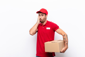 feeling shocked and astonished holding face to hand in disbelief with mouth wide open. delivery...