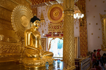 Golden Buddha statue inside the Wat Phrathat Nong Bua temple in Ubon Ratchathani, Thailand