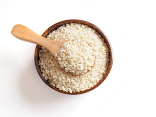 Cereal dried food whole grains with white sesame seeds in wooden spoon isolated on white background.