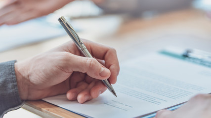 Business people sign investment agreements to buy and sell business.