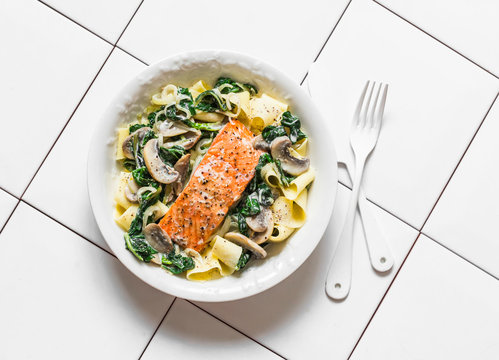 Pappardelle Pasta With Creamy Spinach Mushrooms Sauce And Baked Salmon On A Light Background, Top View