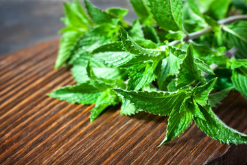 Fresh mint leaves on old wooden background © amberto4ka