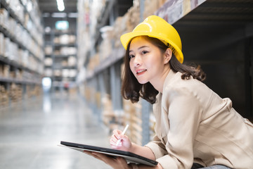 Pretty worker checking stock in the warehouse. Asian beautiful young woman worker of furniture store.Businesswoman using tablet in distribution stock.