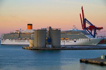 Costa Cruises cruiseship or cruise ship liner Costa Deliziosa in industrial port with silos and...