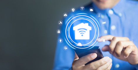 Smart Home concept, Man using mobile phone with internet of things technology of home automation system, copy space