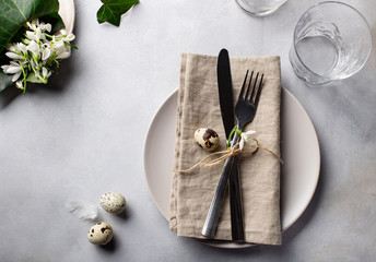 Easter table setting decorated with quail eggs and spring flowers. natural neutral colors. horizontal image
