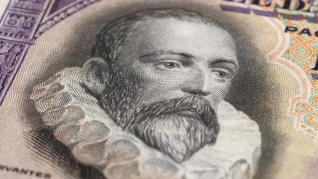 Miguel de Cervantes portrait on Spain 100 pesetas banknote (1928) rotating. Famous Spanish writer. Low angle, macro. 4K, 422 10 bit