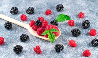 raspberries and blackberries on a wooden spoon