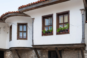 Fototapeta na wymiar Old Town of Nesebar. Authentic cute facade of a Bulgarian house. ground floor made of stone