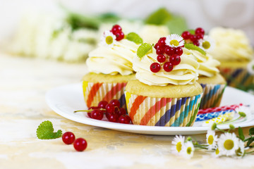 Gentle cupcake with cream and berries on a light background