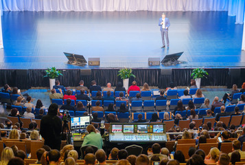 Visitors of business education forum listen to lecture in large hall