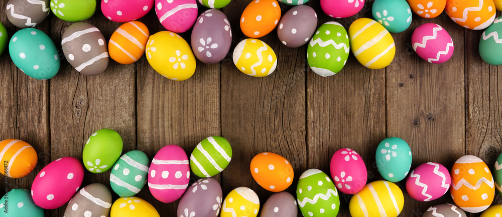 Poster colorful easter egg banner with double border against a rustic old wood background. above view with 