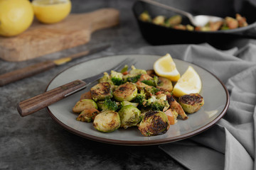 Roasted brussels sprouts portion. Healthy, homemade vegan food or loose weight. Dark background.