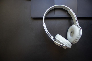 Bluetooth headphone resting on a laptop on a office desk