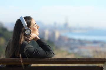 Businesswoman relaxing listening to music outdoors