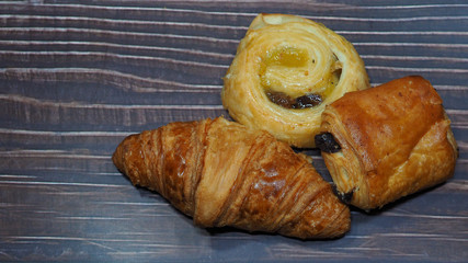 Traditional french butter croissant, Raisin Swirl and Chocolatine on wooden background