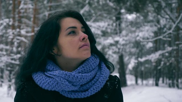 Sad Beautiful Girl Thinking Walking In Winter Forest During Snowfall. Vacation on Nature. Cold Frost Weather. Snow Covered Trees In Wood. Slow motion 60 fps
