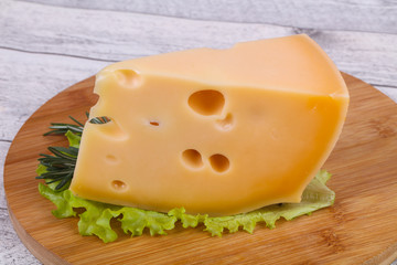 Maasdam cheese  in the board served salad leaves