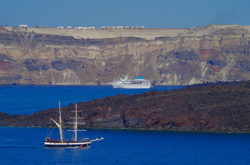 White classic Celestyal Cruises cruiseship or cruise ship liner anchored in bay of volcanic Greek...