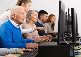 Obraz premium Side view of young businesswoman helping to older coworkers