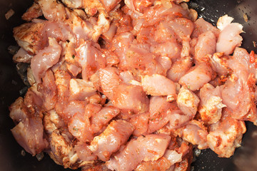 Fresh pieces of raw chicken laid in slow cooker to extinguish.