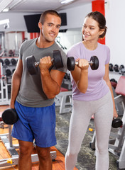 Man and woman posing with dumbbells