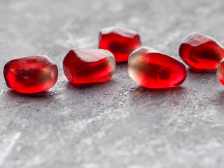 Scattered pomegranate seeds isolated on a gray stone